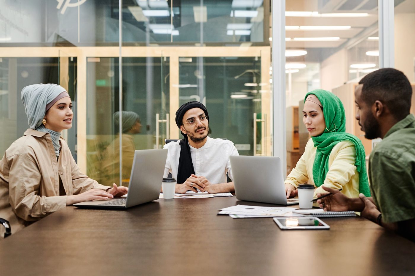 Professioniste e professionisti di diversa provenienza in riunione di lavoro, simbolo della rete di competenze e della cooperazione