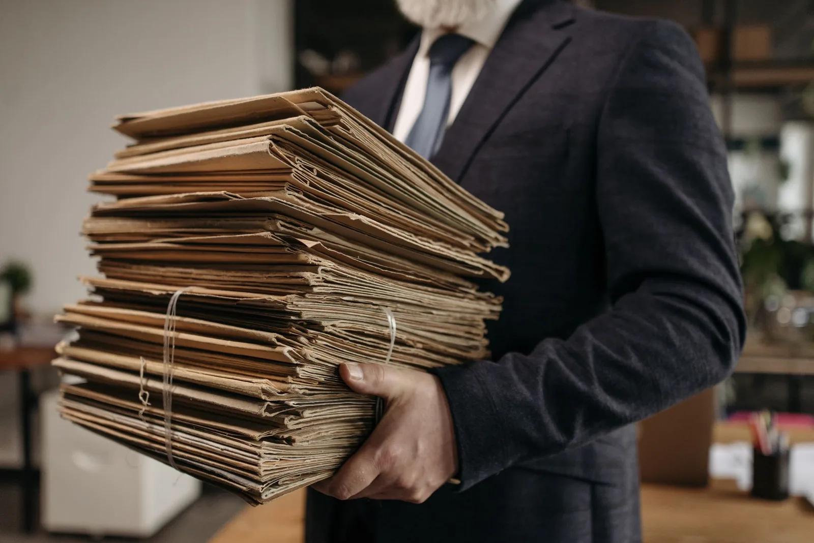 Cartelle e documenti impilati su una scrivania, simbolo dei materiali scaricabili