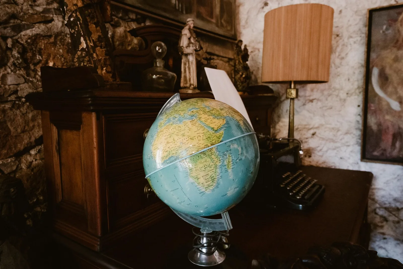 Mappamondo, volumi di diritto e documenti su una scrivania, simbolo del dialogo giuridico tra le tre sponde